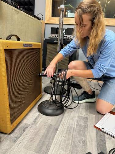 student micing a guitar amplifier
